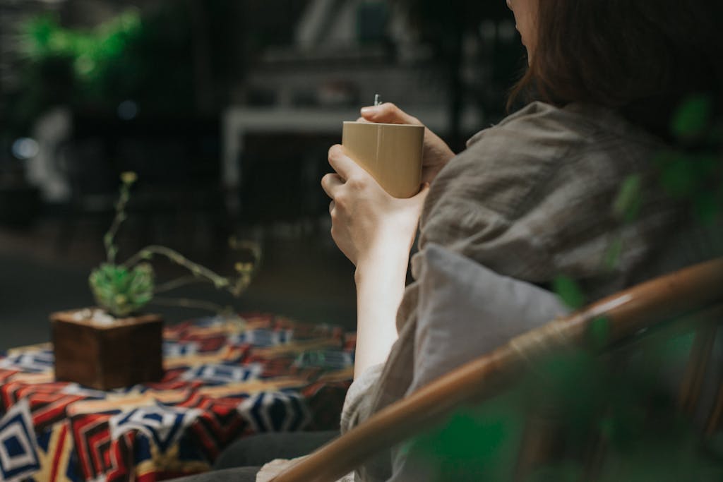 A person enjoying a quiet moment with a mug of coffee in a cozy indoor setting.